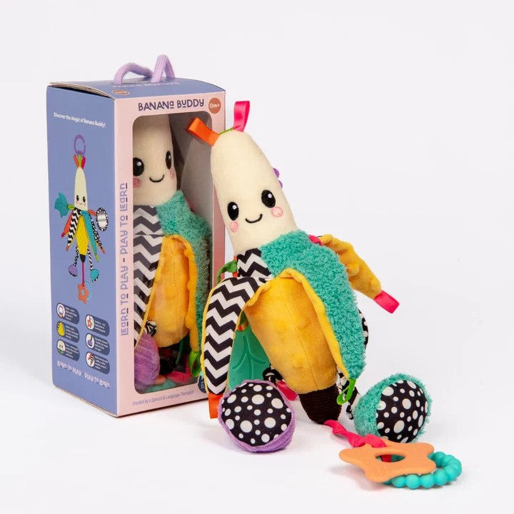 Plush banana baby toy with high-contrast patterns, teal textures, and orange star teether next to its box.
