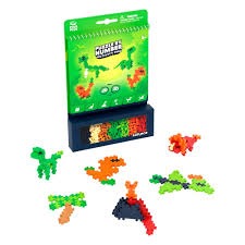 A Plus-Plus Dinosaur building set with a green box and several dinosaur, volcano, and tree models made of colorful pieces.