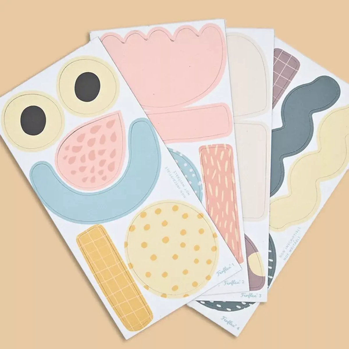 Four sheets of magnetic stickers in pastel rose, blue, and yellow with dots, grids, and abstract wavy shapes.
