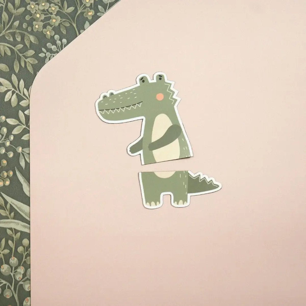 Two-piece green crocodile magnet on a beige rose background with a floral pattern in the corner.
