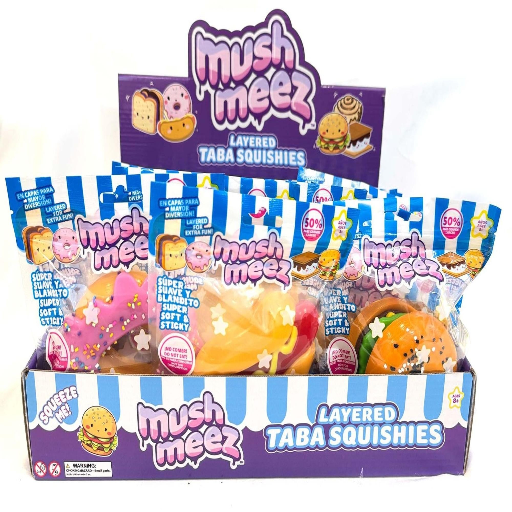 Retail display of food-themed Mush Meez Layered Taba Squishies in colorful blue and white striped packaging.