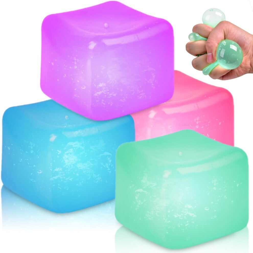 Four colorful, translucent squishy cubes in purple, pink, blue, and green, with a hand squeezing the green cube.