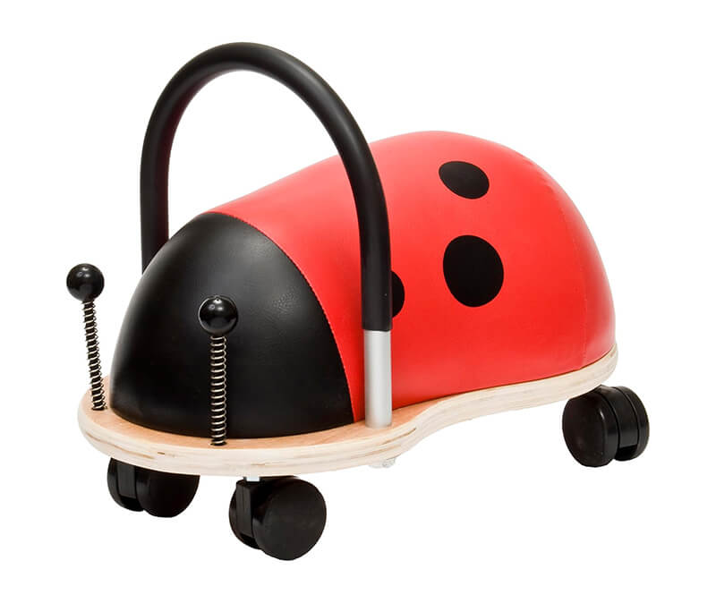 Ladybug-themed ride-on toy with a red padded body, black spots, wooden base, and four black caster wheels.