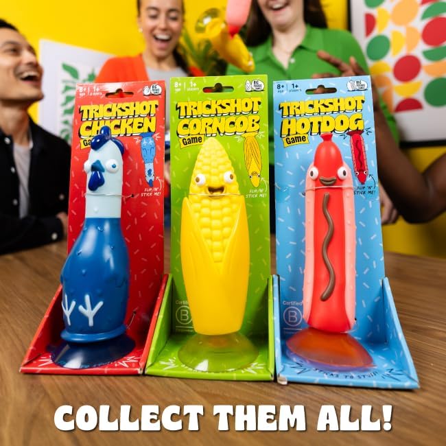 Three colorful Trickshot toys in packaging featuring a blue chicken, a yellow corn cob, and a red hotdog with suction bases.